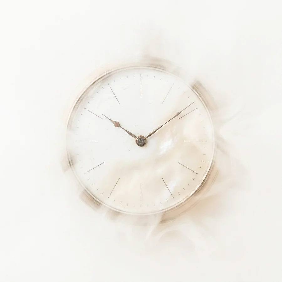 A pale clock face dissolving into mist